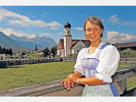 Meine Heimat und ich: Biathlon-Star Magdalena Neuner posiert im Dirndl vor der Dorfkirche von Wallgau. Meine Heimat und ich: Biathlon-Star Magdalena Neuner posiert im Dirndl vor der Dorfkirche von Wallgau.
