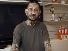 Toumaniantz&lsquo; Gesicht ist mit Tattoos bedeckt, seine&nbsp;Lippen und Ohren sowie seine Nase und Augenbrauen&nbsp;sind&nbsp;mit Piercings durchl&ouml;chert.