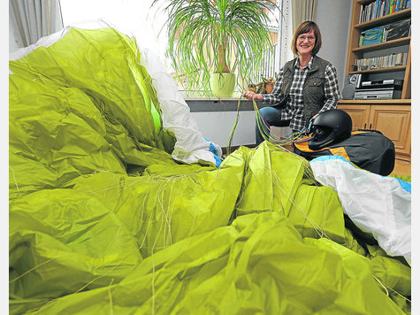&bdquo;Das Tolle an diesem Sport ist, dass man das Flugger&auml;t immer mitnehmen kann&ldquo;: Annemarie Metzenroth (62) mit ihrem Gleitschirm im Wohnzimmer in A&szlig;ling. Foto: Stefan Rossmann