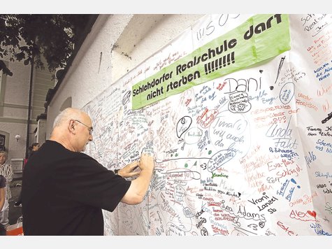 Die Realschule Schlehdorf darf nicht sterben: Hans N&ouml;th aus Stuttgart unterschreibt auf dem Protest-Plakat gegen die Schlie&szlig;ung. Seine Enkelin soll nicht zu den letzten Absolventinnen der renommierten Einrichtung geh&ouml;ren. Foto: arp
