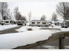Wintercamping - Wohnwagen auf dem verschneiten Campingplatz in Brunnen im Schwangau (Bayern)