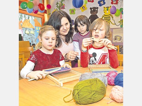 Ana, Maja und Luan (v.li.) weben mit Erzieherin Astrid Demme: Der Kindergarten St. Stefan bekommt ein neues Brandschutzkonzept, und die Gemeinde beteiligt sich an den Kosten. foto: js