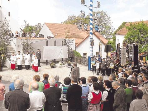 Der Dorfplatz in Schr&ouml;ding ist eingeweiht: B&uuml;rgermeister Hans Grandinger (am Pult) freute sich &uuml;ber die vielen G&auml;ste und die Vereine, die mit ihren Fahnenabordnungen bei der stimmungsvollen Feier am Pfingstsonntag vertreten waren. foto: kuhn