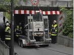 Unfall an Eisenbahnunterführung in München - Höhe unterschätzt: Minnibagger hängt an Brücke