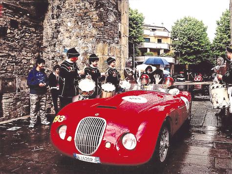 Trommler stehen Spalier: Horst Keil und sein Beifahrer Gino Perbellini im roten Jaguar-Biondetti-Rennwagen. Foto: fkn