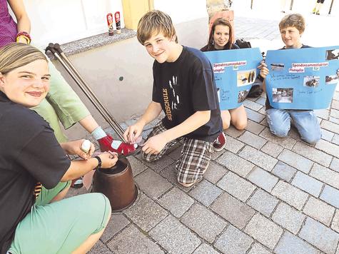 Eine saubere Sache: Mit einer Schuhputzaktion in der Marktstra&szlig;e treiben (v. li.) Julia Wurzer, Tim Haltermann, Yasmin Hohenreiter und Dennis Mayer Spenden auf. Foto: arp